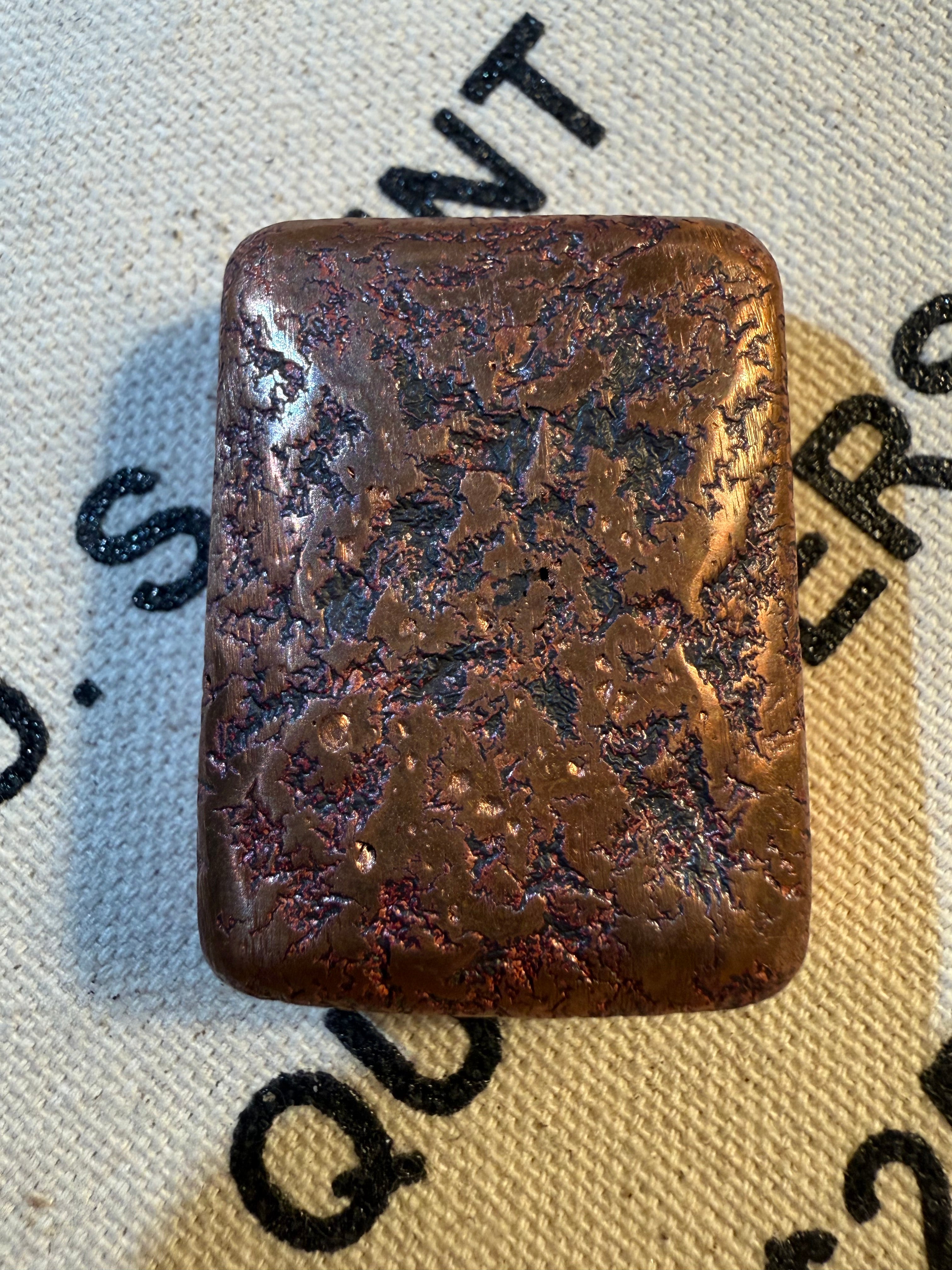 Rust-colored metal object on a textured fabric background