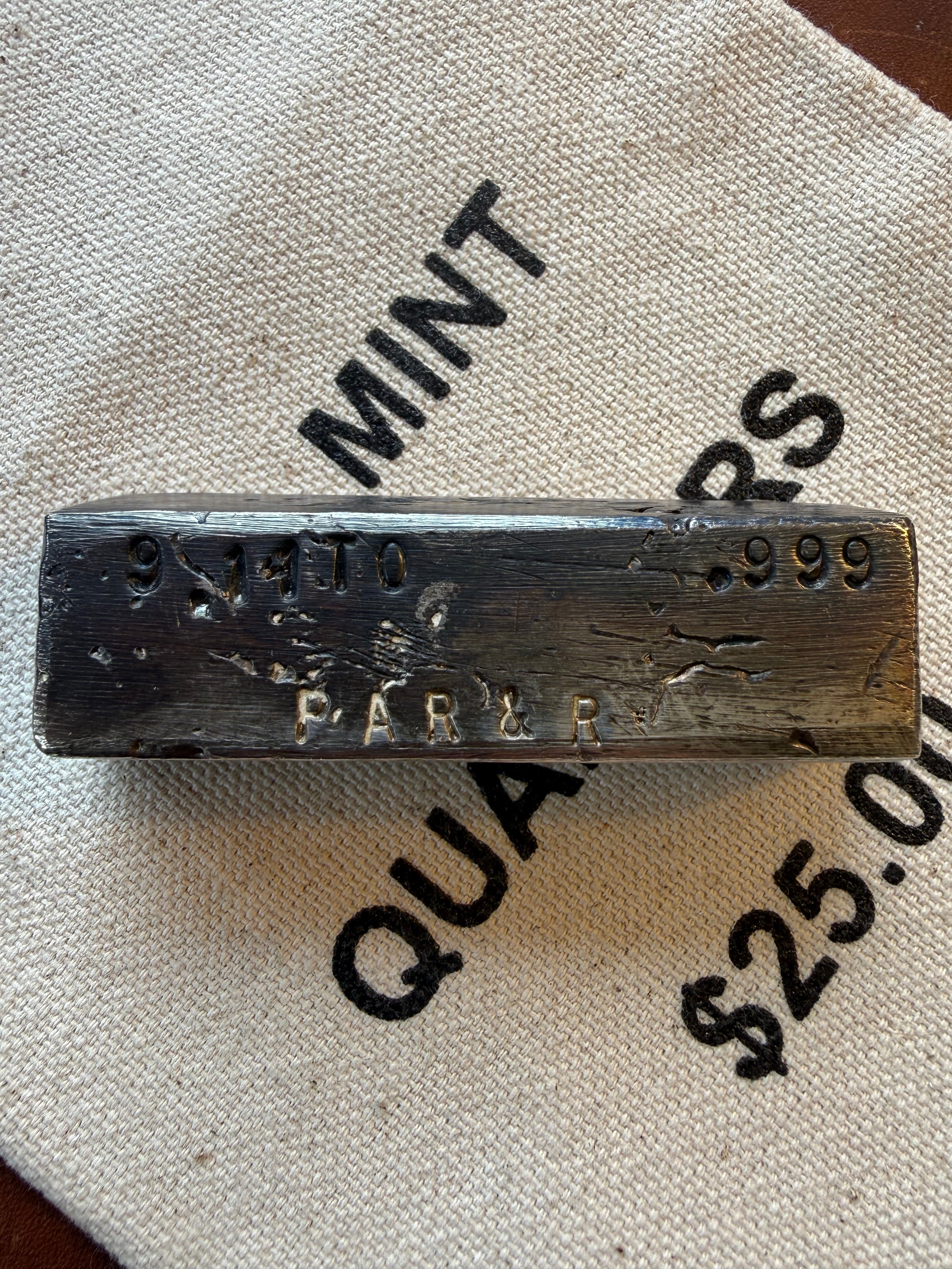 Vintage Silver Bar with 'PAR & R' branding on a textured surface.